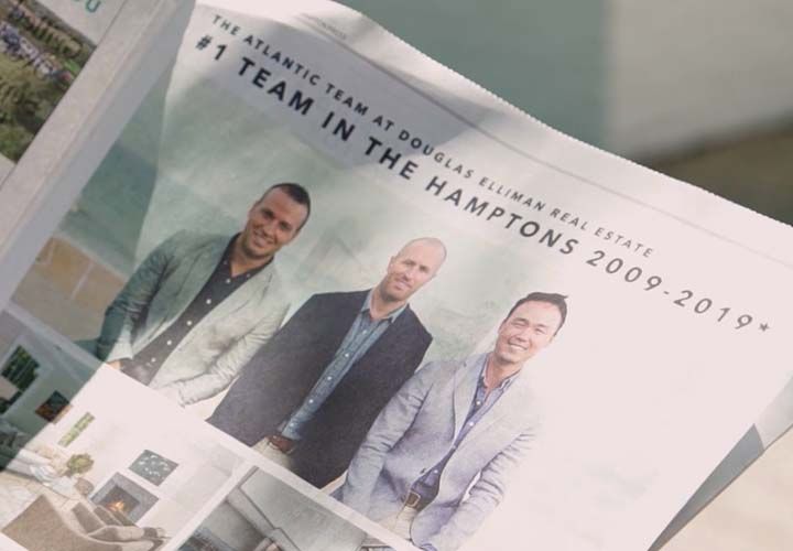 a newspaper real estate ad showing thee men smiling at the camera