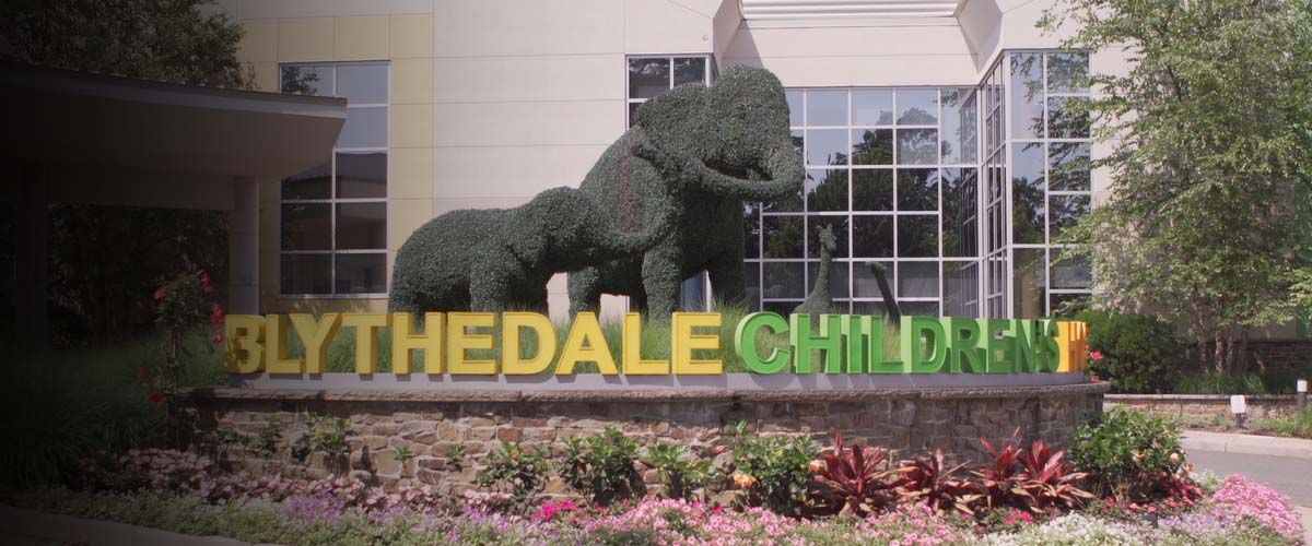trees shaped like elephants in front of a sign that says Blyhtedale Children's Hospital