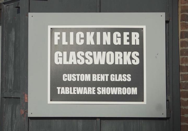 a door sign stating Flickinger Glassworks