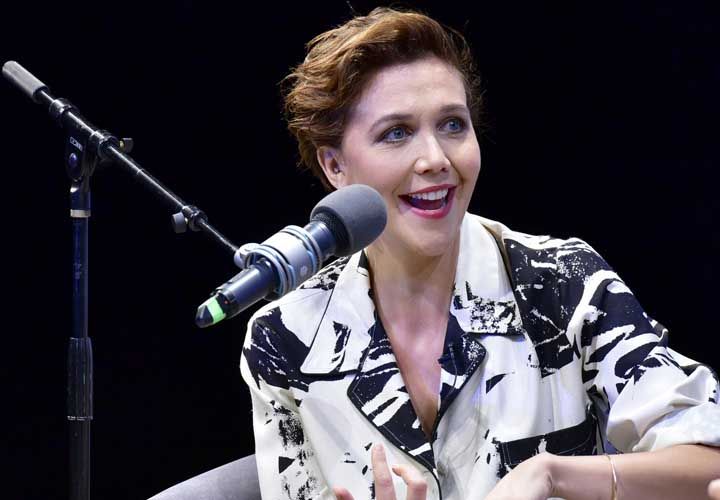 Maggie Gyllenhaal answering a question on stage during an interview