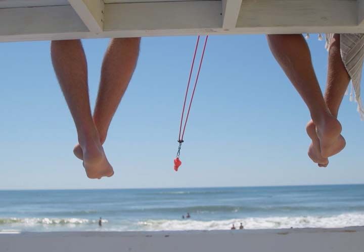 lifeguard feet dangling down from a lifeguard chair