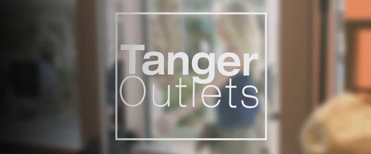 Tanger Outlets logo etched onto a glass door