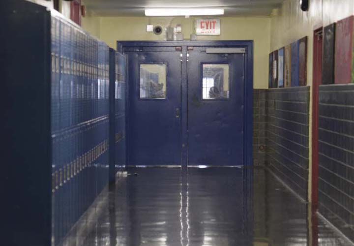 an empty high school hallway with blue lockers