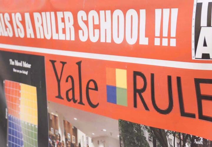 Yale RULER sign hanging on a fence outside of a school